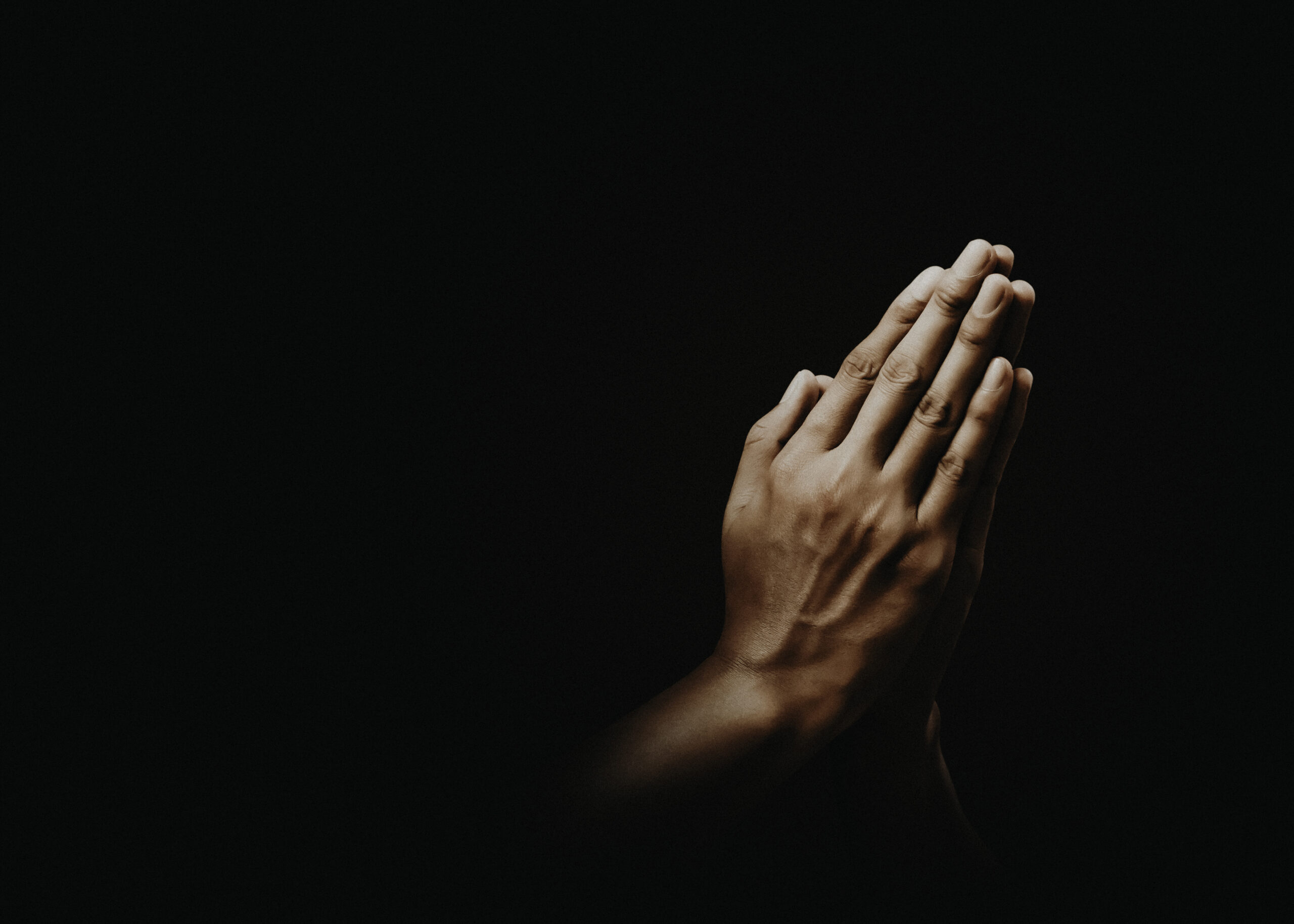 Praying hands with faith in religion and belief in God on dark b.